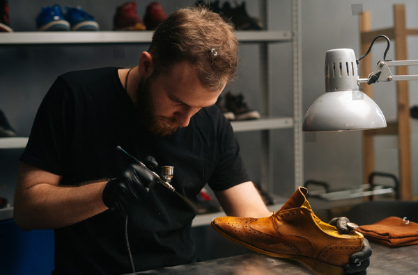 Man restoring a leather shoe with tools