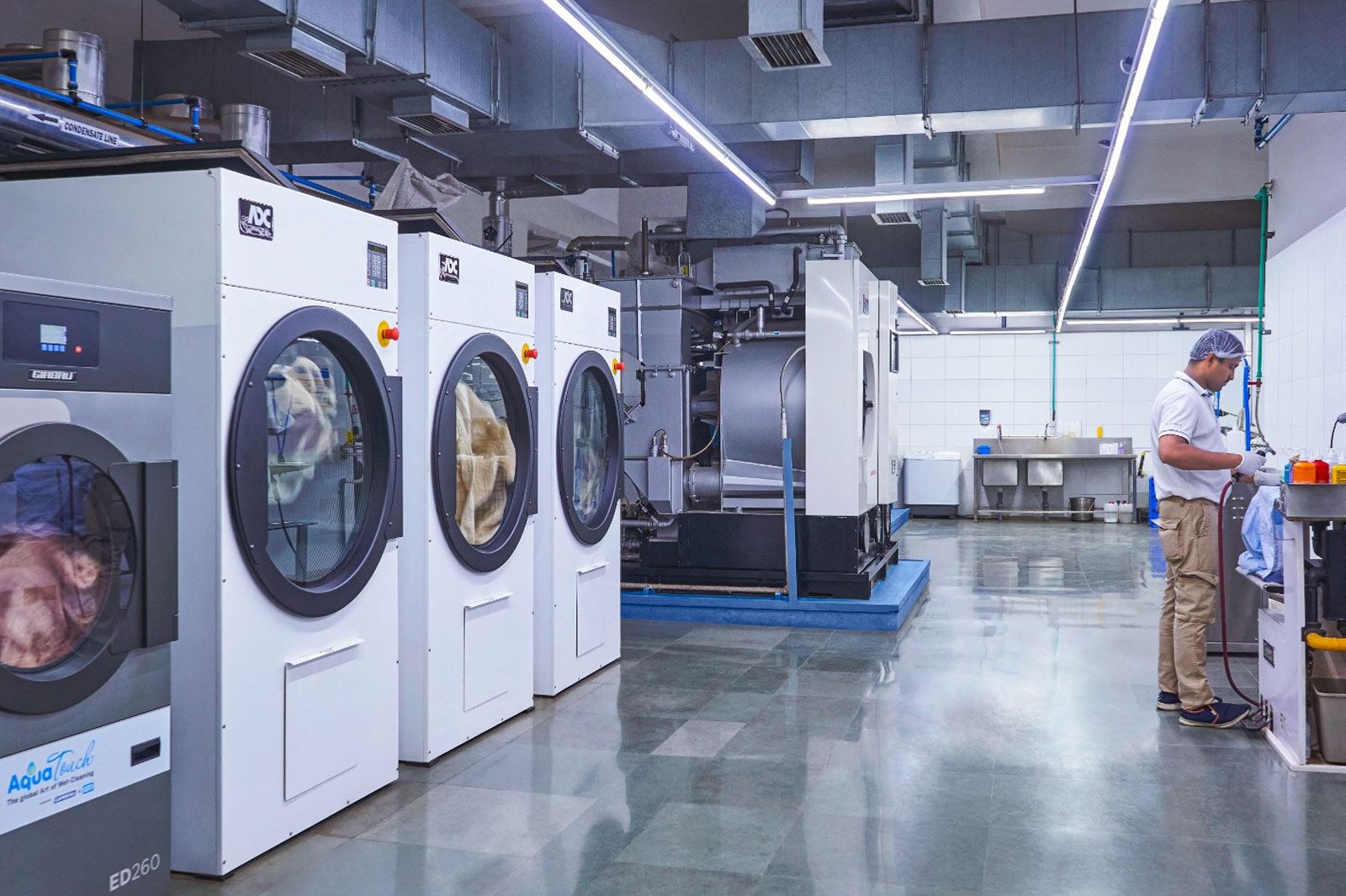 Modern laundry facility with industrial washing machines and garment tech in Mumbai.