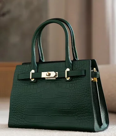 Dark green luxury handbag with structured handles and metallic detailing