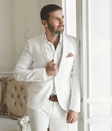 Man wearing an elegant white suit representing premium garment care and dry cleaning services