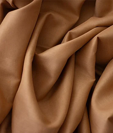 Close-up of soft brown fabric representing premium laundry and garment care