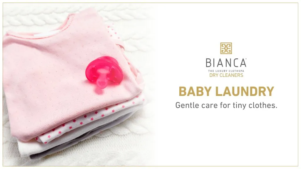 Folded baby clothes with pacifier – gentle baby laundry services in Mumbai.