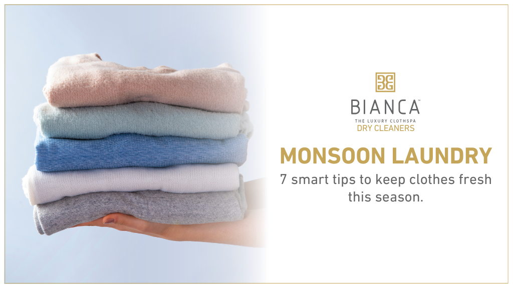 Hand holding folded clothes with laundry tips.