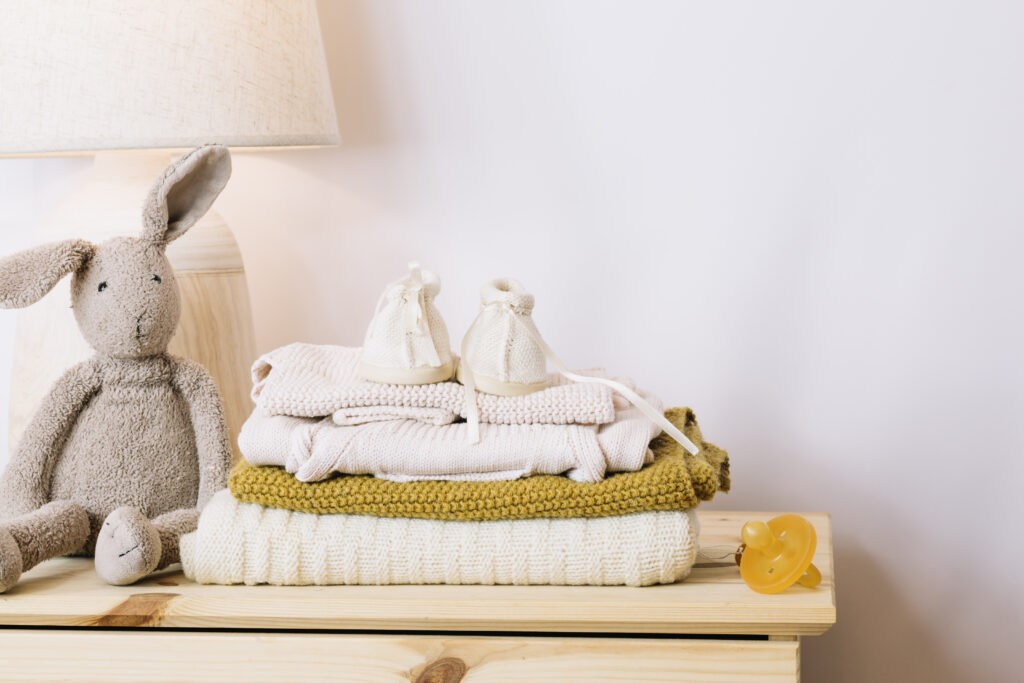 Folded baby clothes, booties, and pacifier – gentle laundry care for new parents in Mumbai.